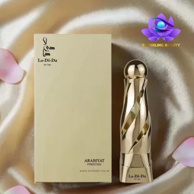 Frasco e caixa de perfume La-Di-Da ARABIYAT PRESTIGE sobre tecido cor de champanhe.
