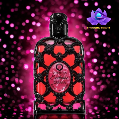 Frasco vermelho de perfume ornado a preto e texto no rótulo em fundo rosa desfocado