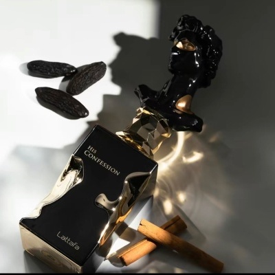 Frasco de perfume artístico preto e dourado com paus de canela e favas de baunilha.