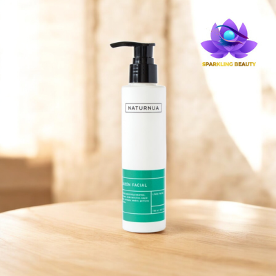 Frasco branco de sabonete facial NATURNUA com rótulo verde sobre mesa de madeira.