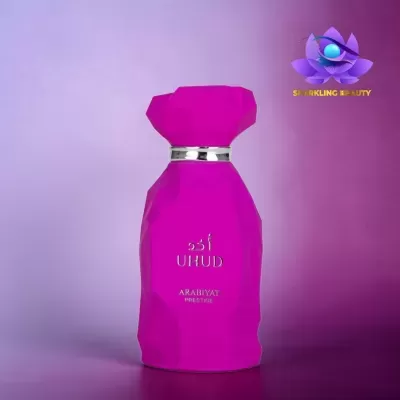 Frasco de perfume rosa choque facetado com texto prateado e logótipo Sparkling Beauty no fundo roxo
