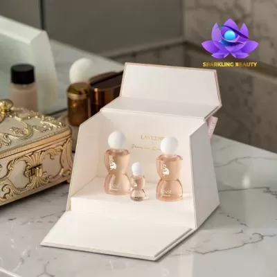 Conjunto de frascos de perfume em caixa branca sobre superfície de mármore