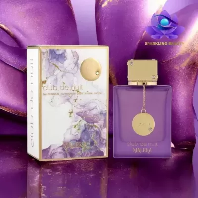 Frasco de perfume roxo ao lado da embalagem branca com padrão roxo e dourado.