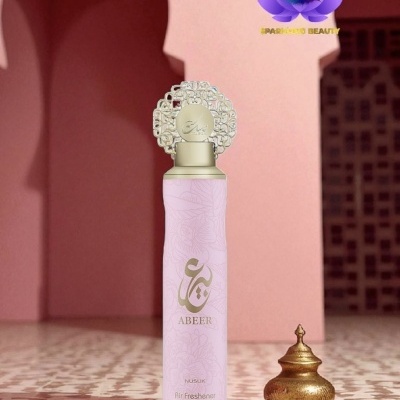 Frasco rosa claro com tampa dourada decorativa e objeto dourado ao lado em ambiente rosa com chão geométrico