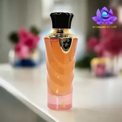 Frasco de perfume laranja com tampa preta e detalhes dourados