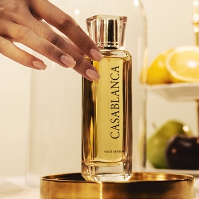 Frasco de perfume CASABLANCA da Swiss Arabian numa base dourada com limões ao fundo