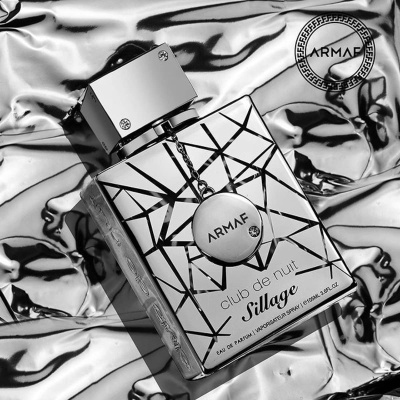 Frasco de perfume ARMAF Club de Nuit Sillage sobre tecido prateado