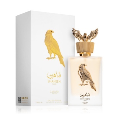 Frasco de perfume SHAHEEN GOLD com caixa ao lado, ambos brancos com detalhes dourados de uma águia.