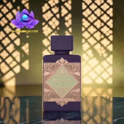 Garrafa de perfume roxa com rótulo decorativo cobre e verde sobre superfície preta