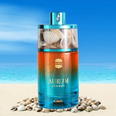 Frasco de perfume Ajmal Aurum Summer com tampa transparente e conchas, sobre areia e fundo de mar