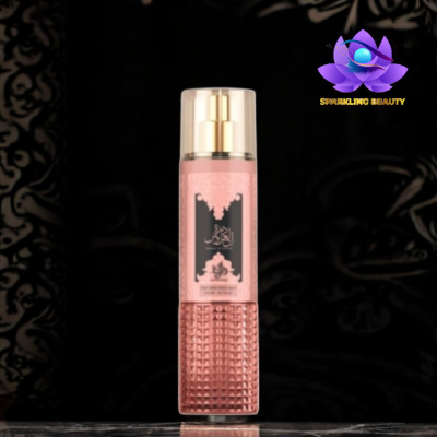 Frasco de spray corporal rosa com tampa dourada e rótulo preto com texto em árabe