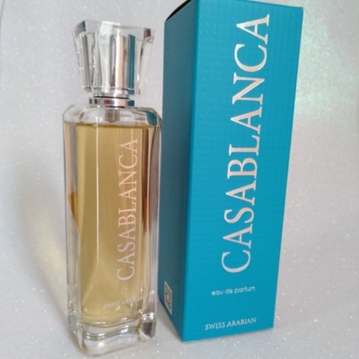 Frasco transparente de perfume Casablanca ao lado de caixa azul