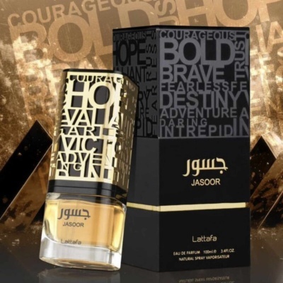 Frasco de perfume JASOOR Lattafa dourado com embalagem preta e dourada sobre fundo dourado