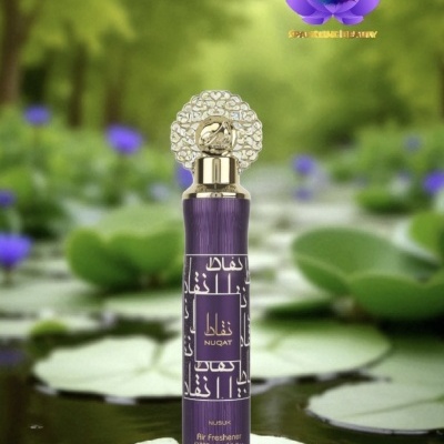 Frasco roxo de ambientador NUQAT com tampa dourada sobre folhas de lírio na água