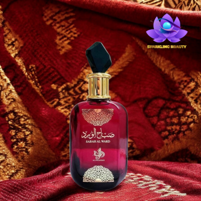 Frasco de perfume vermelho escuro com tampa preta sobre tecido decorativo vermelho e dourado