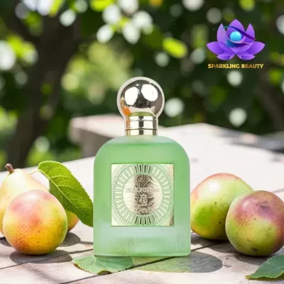 Frasco de perfume verde fosco com tampa metálica redonda e etiquetas douradas junto a peras sobre mesa em exterior