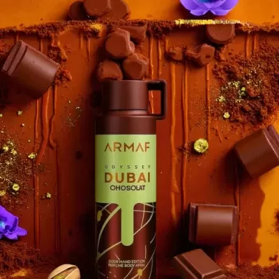 Frasco de perfume Armaf Odyssey Dubai Oh Solat rodeado de pedaços de chocolate e flores roxas