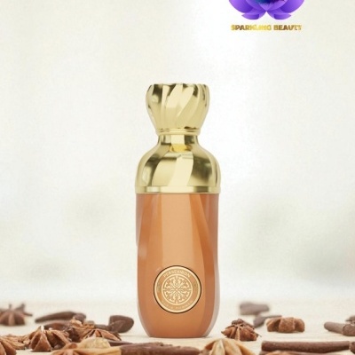 Frasco de perfume dourado com selo circular, rodeado por especiarias e logótipo SPARKLING BEAUTY