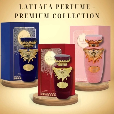 Três frascos de perfume Lattafa Premium Collection em azul, vermelho e rosa com decoração dourada, cada um em base de madeira, junto às suas caixas coloridas.