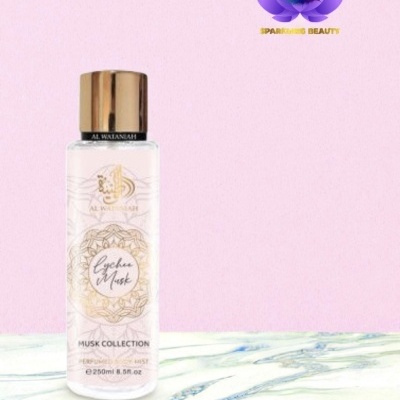 Frasco de spray corporal Al Wataniah Lychee Musk com tampa dourada sobre superfície marmoreada e fundo rosa