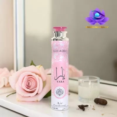 Spray ambientador YARA rosa com rosa e copo em fundo neutro