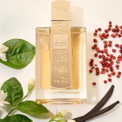 Frasco de perfume com tampa dourada rodeado por bagas vermelhas, baunilha e folhas com flores brancas