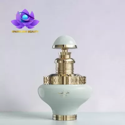 Frasco de perfume verde claro com detalhes dourados e texto JUMAN