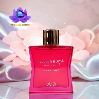 Frasco de perfume rosa com tampa dourada e texto branco em fundo com pétalas e tecido brilhante