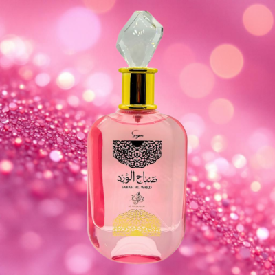 Frasco de perfume rosa com tampa de cristal e texto em árabe e inglês no fundo rosa