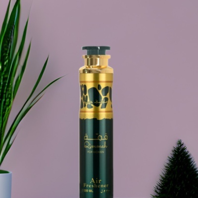 Ambientador spray preto e dourado com texto dourado, rodeado por plantas, fundo lilás