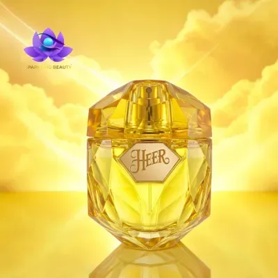 Frasco de perfume amarelo dourado com etiqueta HEER e fundo amarelo com nuvens