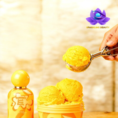 Gelado amarelo Sweet Mango Melody com frasco amarelo ao lado e colher metálica, fundo claro