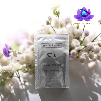 Embalagem prateada de produto cosmético NATURNUA FANGO ESPIRIT com flores brancas e lilases ao fundo