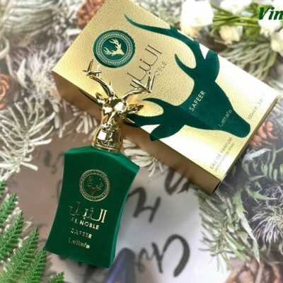 Frasco de perfume verde com tampa dourada em forma de cabeça de veado junto à caixa dourada com imagem de veado