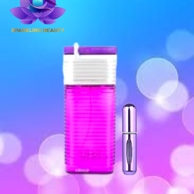 Frasco de perfume rosa translúcido com tampa roxa e branca e pequeno frasco metálico prateado em fundo azul e rosa