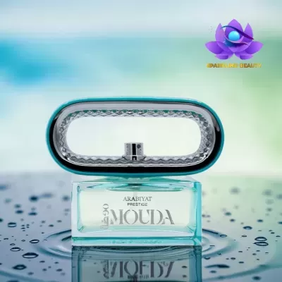 Frasco de perfume ARABIYAT PRESTIGE MOUIDA azul claro com tampa oval prateada em superfície molhada