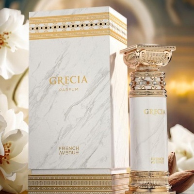 Frasco e caixa de perfume branca marmorizada com texto dourado, decorados com elementos dourados inspirados em colunas gregas, com flores brancas ao redor.