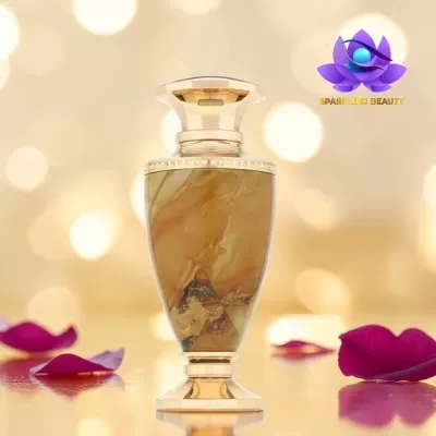 Frasco de perfume dourado com padrão marmoreado e pétalas de rosa