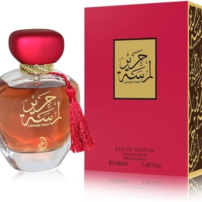 Frasco de perfume com tampa vermelha e caixa vermelha com texto em árabe e dourado