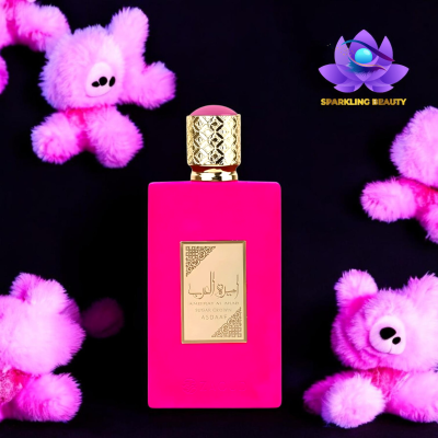 Frasco de perfume rosa fúcsia com tampa dourada e peluches de urso cor-de-rosa no fundo preto