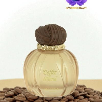 Frasco de perfume azul esfumado com tampa marrom sobre sementes