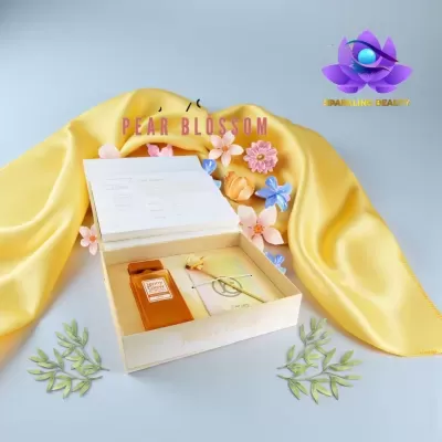 Conjunto de perfume em caixa aberta com decoração de flores e pano amarelo