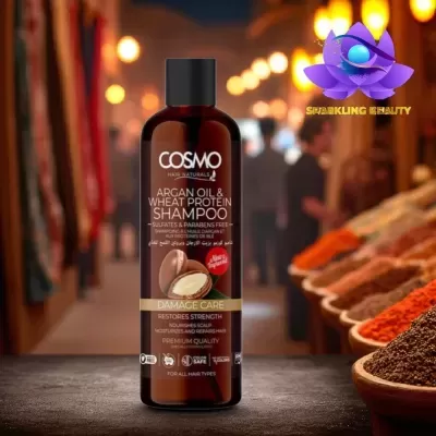 Frasco de champô COSMO com óleo de argão e proteína de trigo numa superfície escura