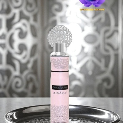 Frasco de ambientador rosa com tampa decorativa numa bandeja metálica com fundo ornamental cinza e branco