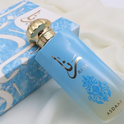 Frasco de perfume azul com tampa dourada e caixa azul com texto e padrão branco
