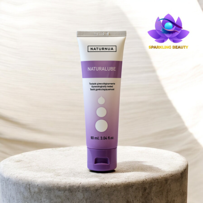 Tubo de creme branco e lilás NATURNUA NATURALUBE sobre superfície de pedra cinza