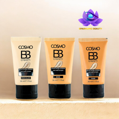 Três tubos de creme COSMO BB em cores diferentes com tampa preta sobre superfície clara.