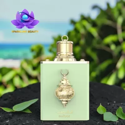Frasco verde claro de perfume com detalhes dourados e ornamento em relevo