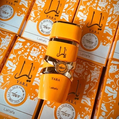 Frasco de perfume laranja Yara com caixas estampadas em fundo