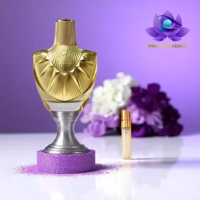Frasco de perfume dourado sobre pedestal com espuma roxa e flores ao fundo